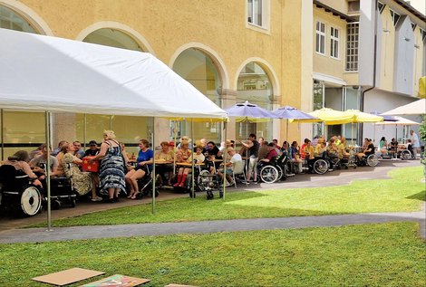 BewohnerInnen bei Tisch im Schatten im Schlosshof