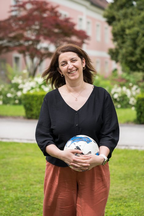 Frau mit Fußball in den Händen