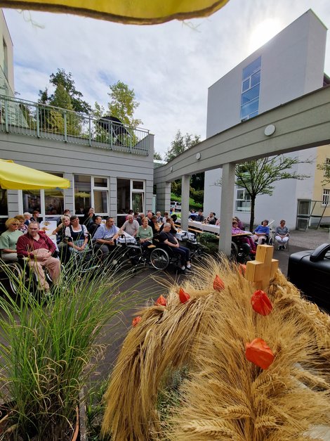 BewohnerInnen und Erntekrone beim Erntedankfest im Freien