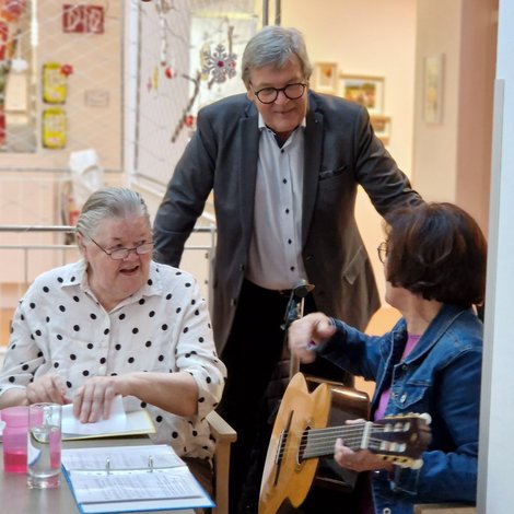 Gitarrenspielerin und zwei Gäste